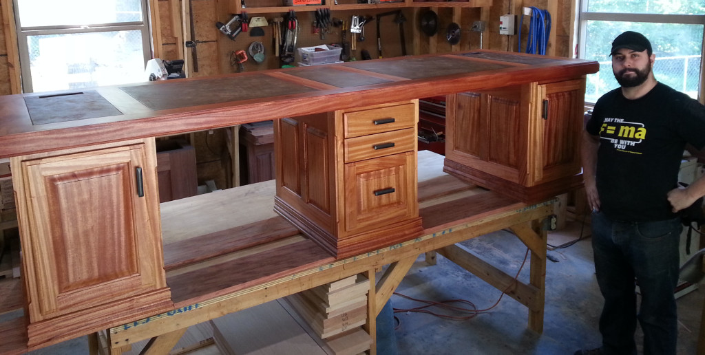 Ray’s son Anthony shows off the company’s unique two-person desk; their original design made of mahogany.